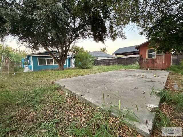 patio terrace at dusk featuring a lawn