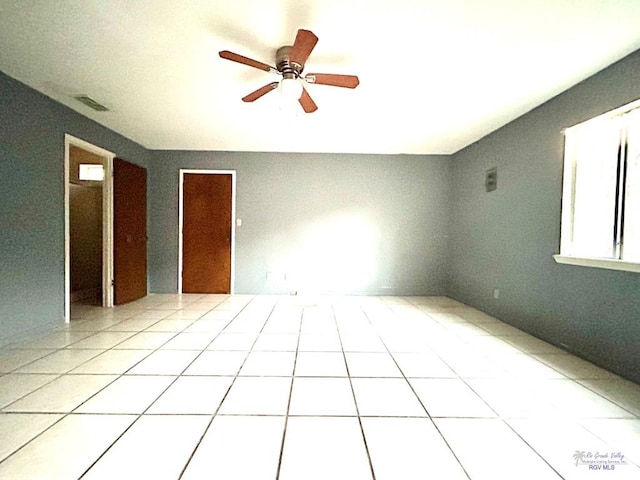 interior space with light tile patterned floors and ceiling fan