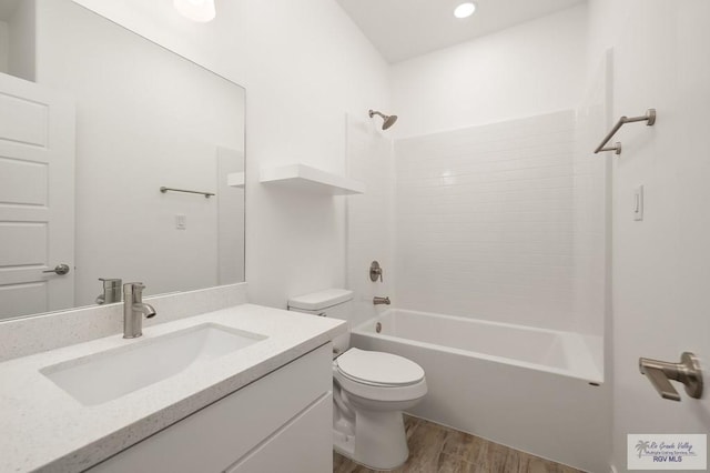 full bathroom featuring vanity,  shower combination, hardwood / wood-style flooring, and toilet