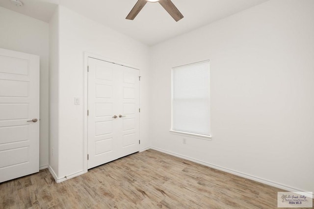 unfurnished bedroom with light wood-type flooring, a closet, and ceiling fan