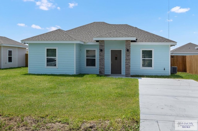 ranch-style home with central AC unit and a front yard