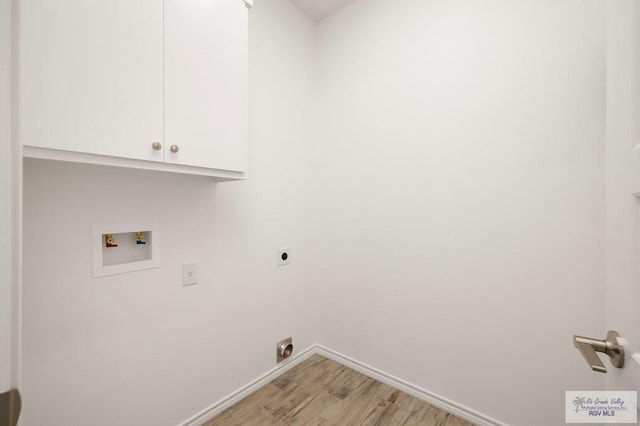 laundry area featuring electric dryer hookup, cabinets, light hardwood / wood-style flooring, and washer hookup