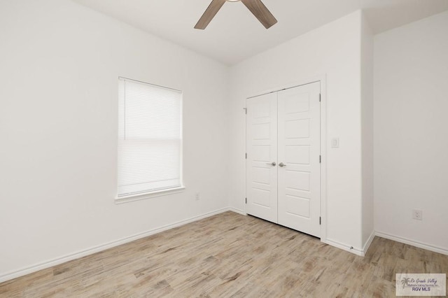 unfurnished bedroom with light wood-type flooring, a closet, and ceiling fan