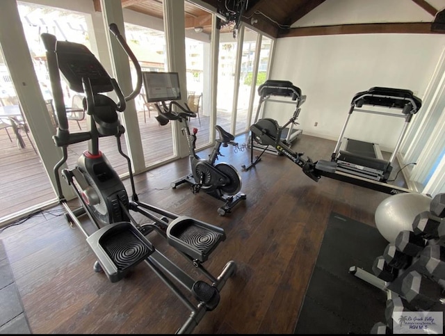 gym with hardwood / wood-style floors and lofted ceiling