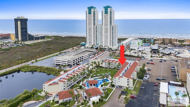 birds eye view of property with a water view and a beach view