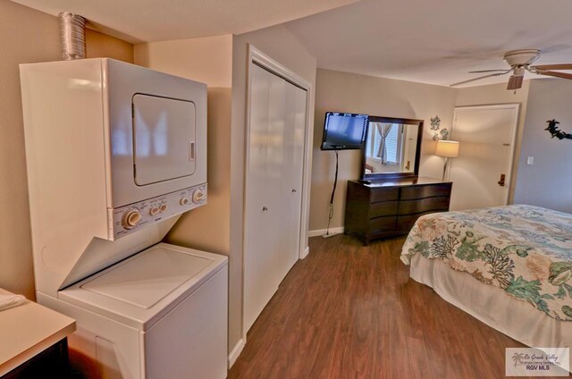 bedroom featuring a closet, ceiling fan, dark hardwood / wood-style flooring, and stacked washer and clothes dryer