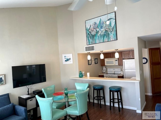 200 S Padre Blvd Unit 1303, South Padre Island, TX 78597 - dining area featuring dark wood-style flooring, a high ceiling, and baseboards