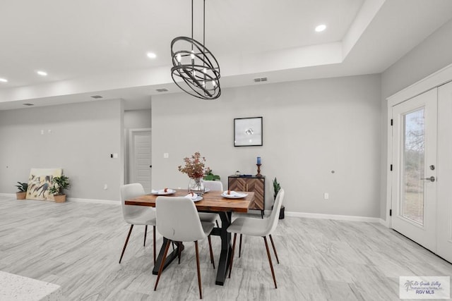 dining area with a tray ceiling and french doors