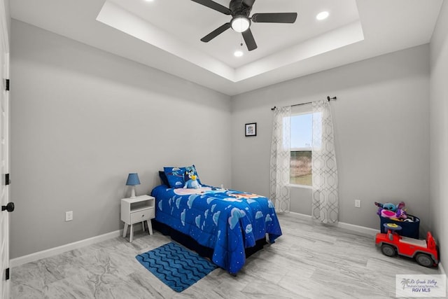 bedroom featuring ceiling fan and a raised ceiling