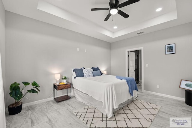 bedroom featuring a tray ceiling and ceiling fan