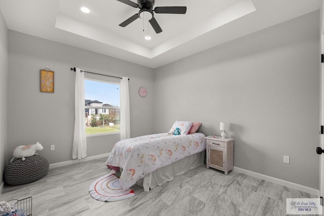 bedroom featuring a tray ceiling and ceiling fan