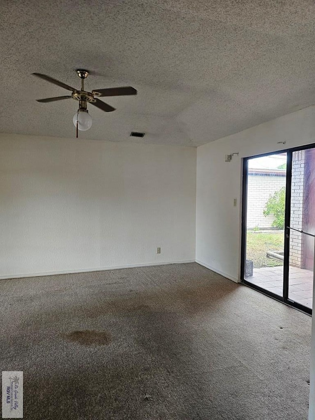 carpeted spare room featuring ceiling fan and a textured ceiling