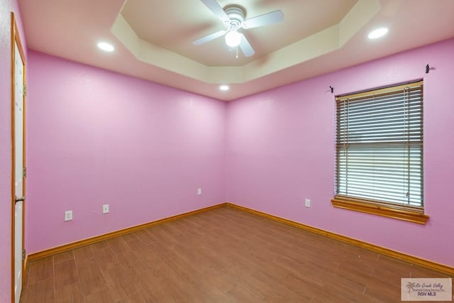 5662 Rustic Manor Dr, Brownsville, TX 78526 - spare room featuring ceiling fan, wood finished floors, recessed lighting, baseboards, and a tray ceiling