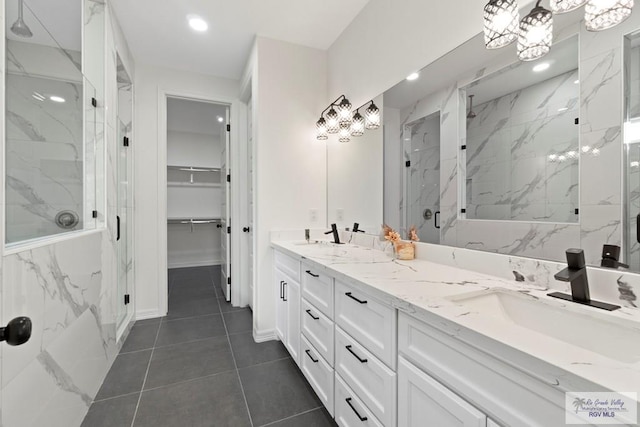 473 Santiago St, La Feria, TX 78559 - bathroom featuring a marble finish shower, double vanity, a walk in closet, and a sink
