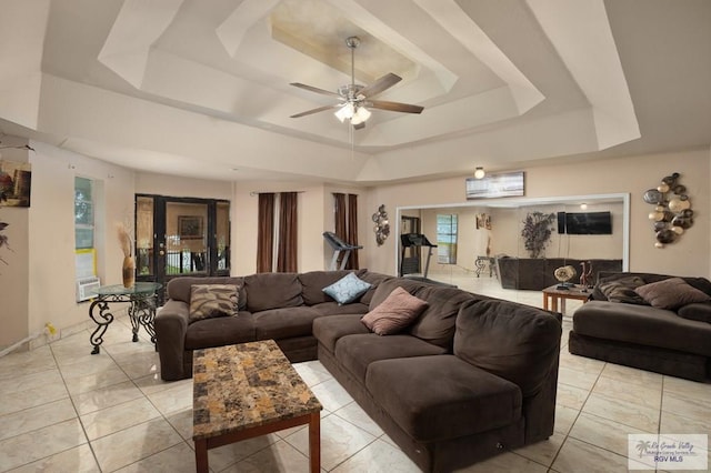 tiled living room featuring a tray ceiling and ceiling fan