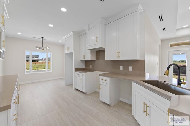 23547 Murphy Ct, Harlingen, TX 78552 - kitchen with a sink, decorative backsplash, recessed lighting, white cabinets, and a chandelier