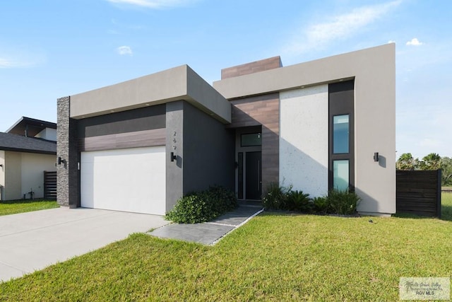 269 Cameo Dr, San Benito, TX 78586 - modern home featuring an attached garage, concrete driveway, a front lawn, and stucco siding