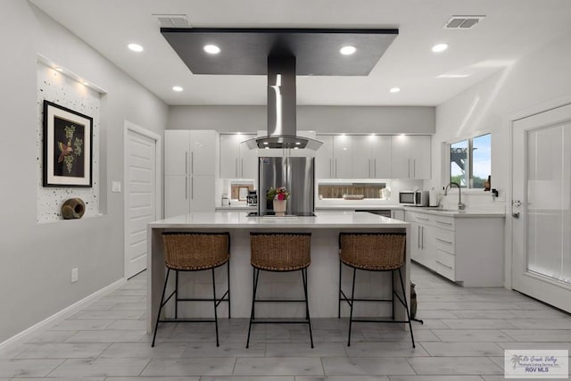 269 Cameo Dr, San Benito, TX 78586 - kitchen featuring stainless steel appliances, modern cabinets, island exhaust hood, a breakfast bar area, and recessed lighting