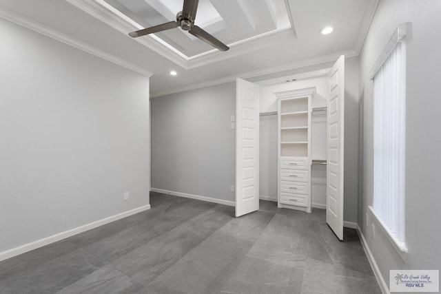 unfurnished bedroom with a walk in closet, a tray ceiling, ceiling fan, crown molding, and a closet