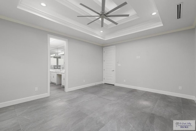 unfurnished room with a raised ceiling, ceiling fan, and ornamental molding