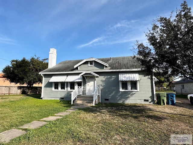 bungalow-style house featuring a chimney, a shingled roof, crawl space, fence, and a front lawn