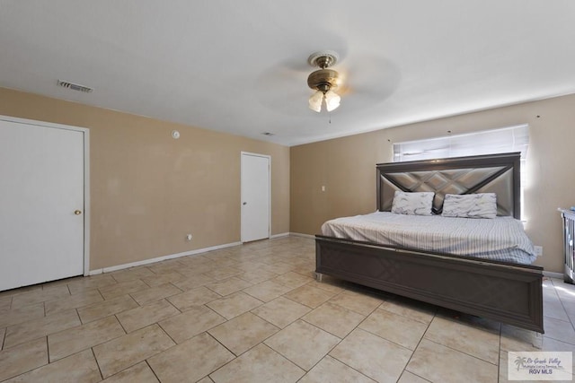 bedroom with a ceiling fan, visible vents, baseboards, and light tile patterned flooring