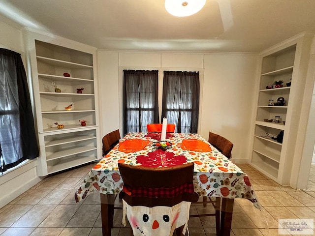 dining space with built in features and light tile patterned flooring