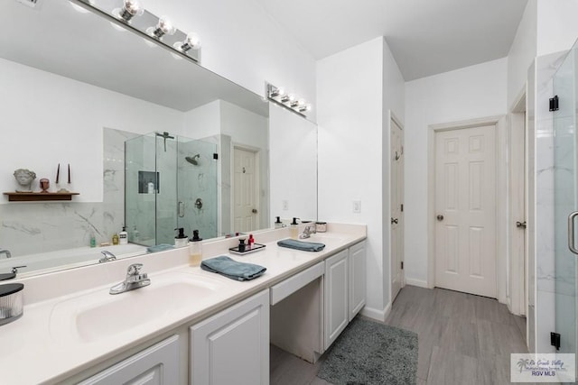 2853 Fleet St, Brownsville, TX 78521 - full bathroom featuring a marble finish shower, double vanity, and wood finished floors