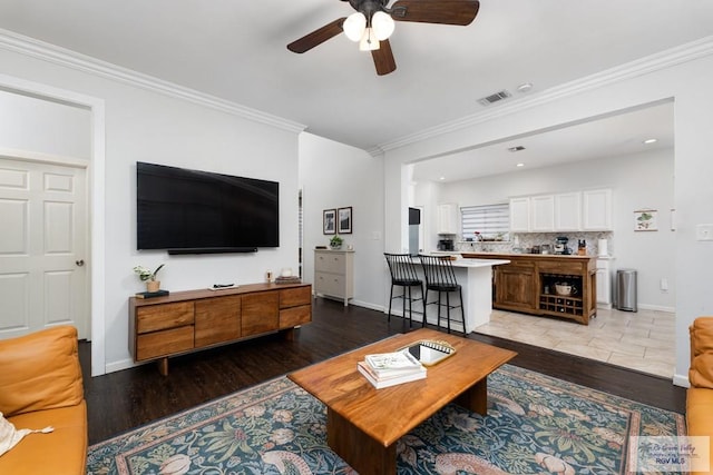 2853 Fleet St, Brownsville, TX 78521 - living room with light wood finished floors, ceiling fan, and ornamental molding