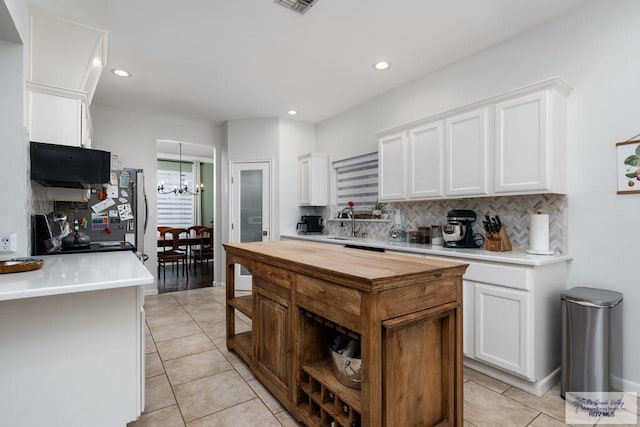 2853 Fleet St, Brownsville, TX 78521 - kitchen with light tile patterned floors, backsplash, white cabinets, a chandelier, and recessed lighting