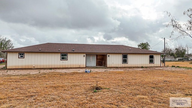 back of house featuring a lawn