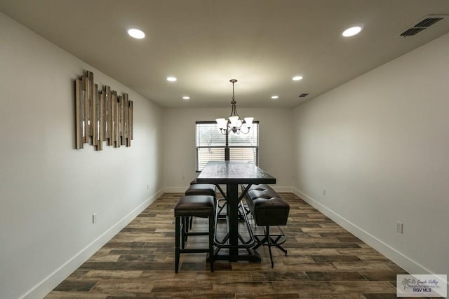 dining space featuring dark hardwood / wood-style flooring and a chandelier