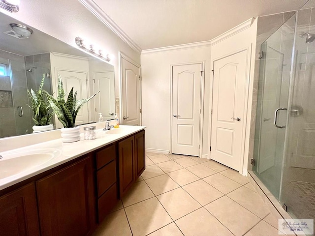 bathroom featuring tile patterned floors, a shower with door, vanity, and ornamental molding