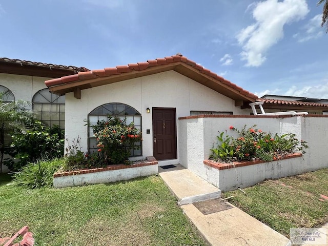 property entrance featuring a lawn