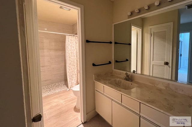 bathroom featuring curtained shower, toilet, vanity, and hardwood / wood-style flooring