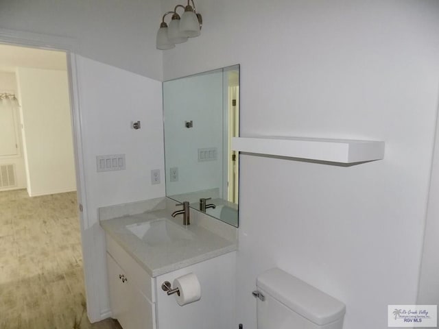 bathroom featuring hardwood / wood-style flooring, vanity, and toilet