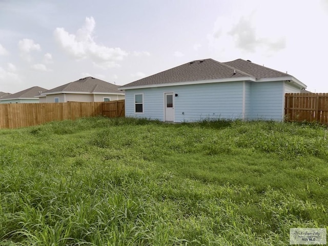 rear view of property featuring a yard