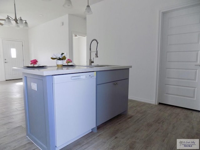 kitchen with sink, wood-type flooring, dishwasher, hanging light fixtures, and an island with sink