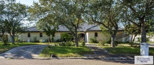 view of front facade with a tile roof and aphalt driveway