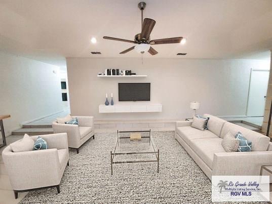 living area with ceiling fan and visible vents