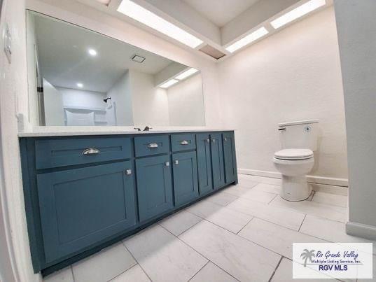 bathroom with vanity, toilet, and baseboards