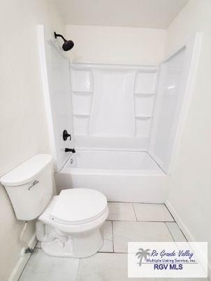 full bath with tile patterned flooring, shower / tub combination, and toilet