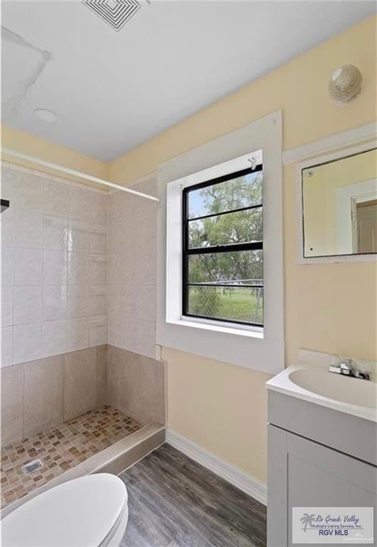 284 Corona Crescent Cir, San Benito, TX 78586 - full bath with vanity, a tile shower, wood finished floors, baseboards, and toilet