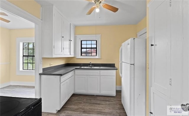 284 Corona Crescent Cir, San Benito, TX 78586 - kitchen with freestanding refrigerator, a ceiling fan, dark wood finished floors, a sink, and dark countertops