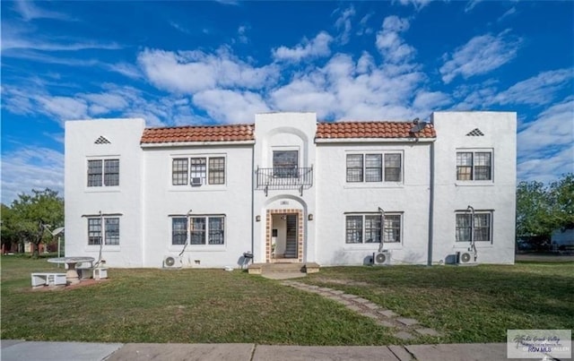 284 Corona Crescent Cir, San Benito, TX 78586 - mediterranean / spanish-style house featuring a tile roof, a front lawn, a balcony, and stucco siding