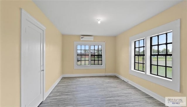 284 Corona Crescent Cir, San Benito, TX 78586 - spare room featuring an AC wall unit, baseboards, and wood finished floors
