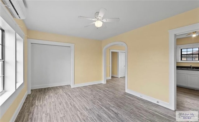 284 Corona Crescent Cir, San Benito, TX 78586 - unfurnished room featuring a wall mounted AC, wood finished floors, a ceiling fan, and a sink