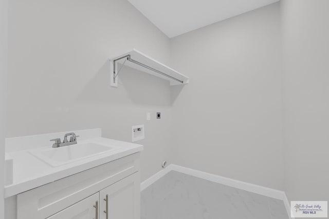 7336 San Andres St, Brownsville, TX 78526 - laundry area with electric dryer hookup, hookup for a washing machine, light marble finish floors, baseboards, and cabinet space
