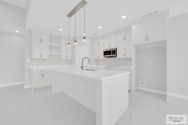 7336 San Andres St, Brownsville, TX 78526 - kitchen with stainless steel microwave, light marble finish flooring, open shelves, a sink, and recessed lighting