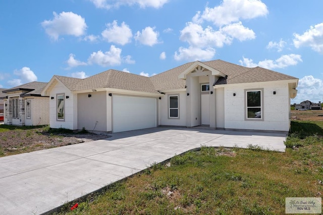 7336 San Andres St, Brownsville, TX 78526 - view of front of property featuring an attached garage, concrete driveway, and a shingled roof